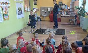 policjanci pokazują dzieciom oznakowanie przejścia dla pieszych