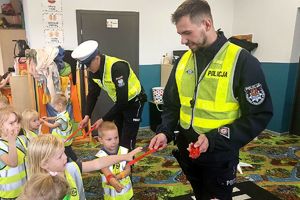 policjanci rozdają dzieciom opaski odblaskowe