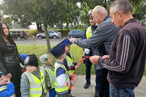 dzieci wręczają odblask przechodniom