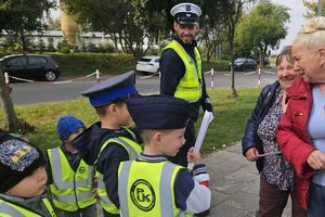 dzieci wręczają odblask przechodniom