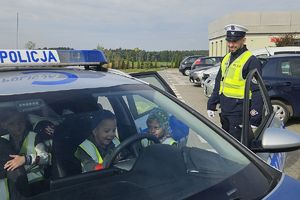 policjant pokazuje dzieciom radiowóz