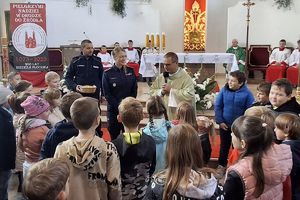 ksiądz i policjanci w otoczeniu dzieci