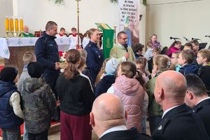 policjanci i ksiądz rozmawiają z dziećmi