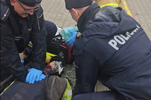 policjanci udzielają pierwszej pomocy poszkodowanemu