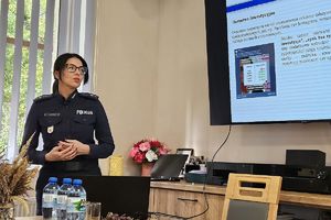 policjantka przedstawia prezentację na temat oszustw inwestycyjnych
