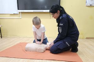 policjantka i chłopiec podczas ćwiczenia resuscytacji