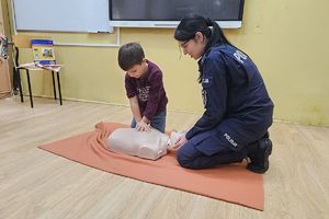 policjantka i chłopiec podczas ćwiczenia resuscytacji
