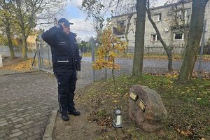 policjant oddaje hołd poległemu policjantowi