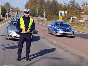 Policjant stoi na drodze.