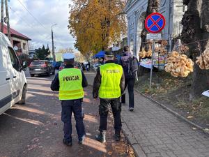 Policjant i Strażnik Miejski stoją w rejonie cmentarza
