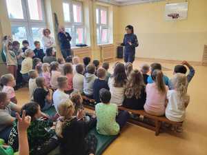 Policjantka stoi i rozmawia z dziećmi