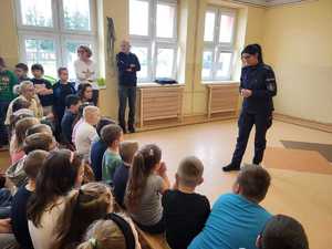 Policjantka stoi i rozmawia z uczniami