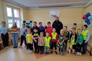 dzieci z elementami odblaskowymi z policjantami