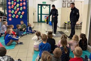 policjanci pokazują dzieciom podstawowe znaki drogowe