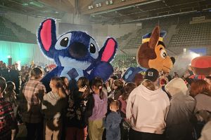 dzieci na płycie hali witają się z maskotkami