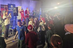 dzieci pod sceną z instruktorką zumby i Świętym Mikołajem