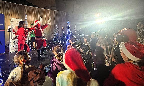 Święty Mikołaj macha ze sceny do dzieci