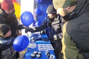 policjantka wręcza dziecku balon policyjny