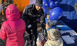 policjantka wręcza dziecku balon