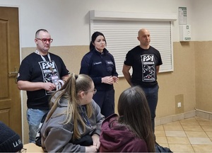 Policjantka stoi i rozmawia z wolontariuszami