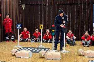 policjantka pokazuje dzieciom światła drogowe