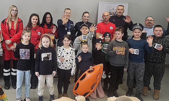 wspólne zdjęcie policjantów i ratowników z dziećmi