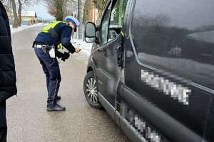 policjant kontroluje stan ogumienia pojazdu