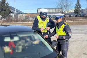 policjantka wręcza kierującemu ulotkę