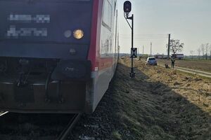 pociąg w tle auto i policjant