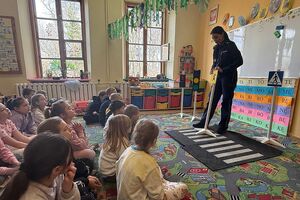 policjantka pokazuje dzieciom znaki drogowe