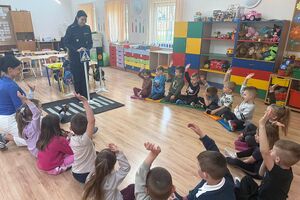 policjantka pokazuje dzieciom znaki drogowe
