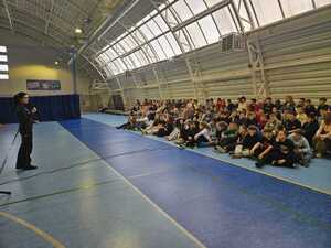 Policjantka stoi i rozmawia z uczniami