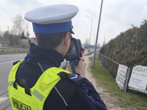 Policjant stoi i na drodze i mierzy prędkość