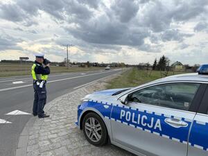 Policjant stoi na drodze i mierzy prędkość