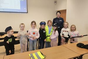 policjantka z dziećmi w czapkach policyjnych