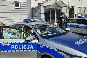 policjant pokazuje dzieciom radiowóz