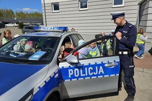 policjant pokazuje dzieciom radiowóz