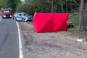 zdjęcie z miejsca wypadku: widać czerwony parawan oraz radiowóz i wóz Straży Pożarnej
