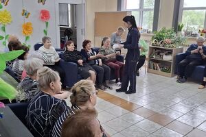 policjantka rozdaje seniorom ulotki