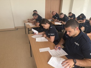 Policjanci siedzą i piszą test.