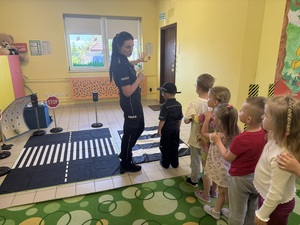 Policjantka tłumaczy jak należy przechodzić przez jezdnie po pasach.