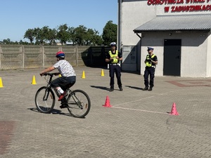 Chłopiec pokonuje tor przeszkód. Policjanci stoją.