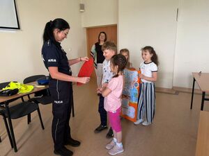 Policjantka otrzymuje podziękowania od dzieci.