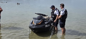 Policjanci stoją przy skuterze wodnym