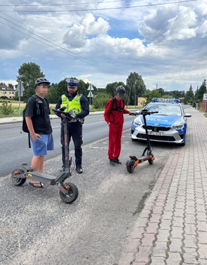 Policjant kontroluje osoby na hulajnogach