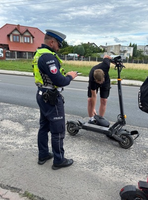 Policjant kontroluje osobę na hulajnodze