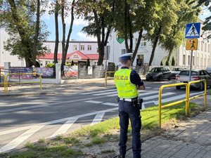 Policjant sprawdza widoczność oznakowania przejścia dla pieszych w rejonie szkoły
