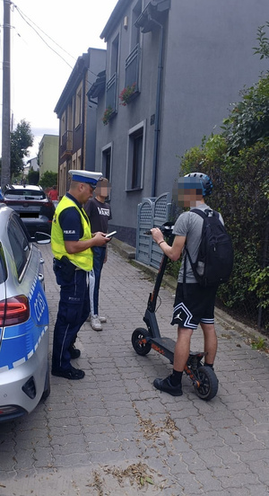 Policjant kontroluje osobę na hulajnodze elektrycznej