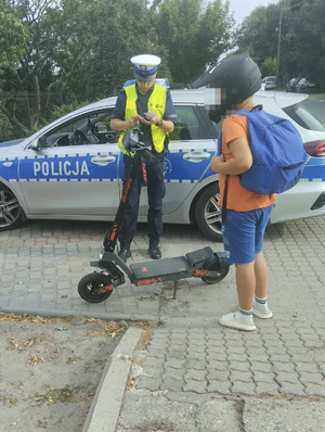 Policjant kontroluje osobę na hulajnodze elektrycznej