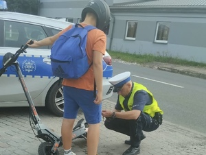 Policjant kontroluje osobę na hulajnodze elektrycznej